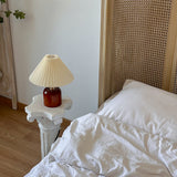 Compact cream pleated table lamp in a neutral bedroom