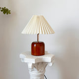 Cream pleated shade lamp with rounded walnut-tone wood base