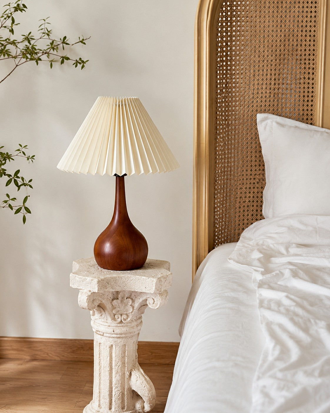 Walnut-tone table lamp beside a bed